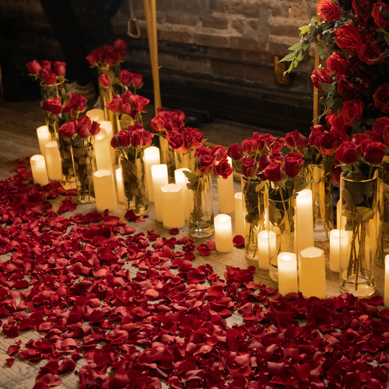 Candles, rose petals, and red roses set for the proposal