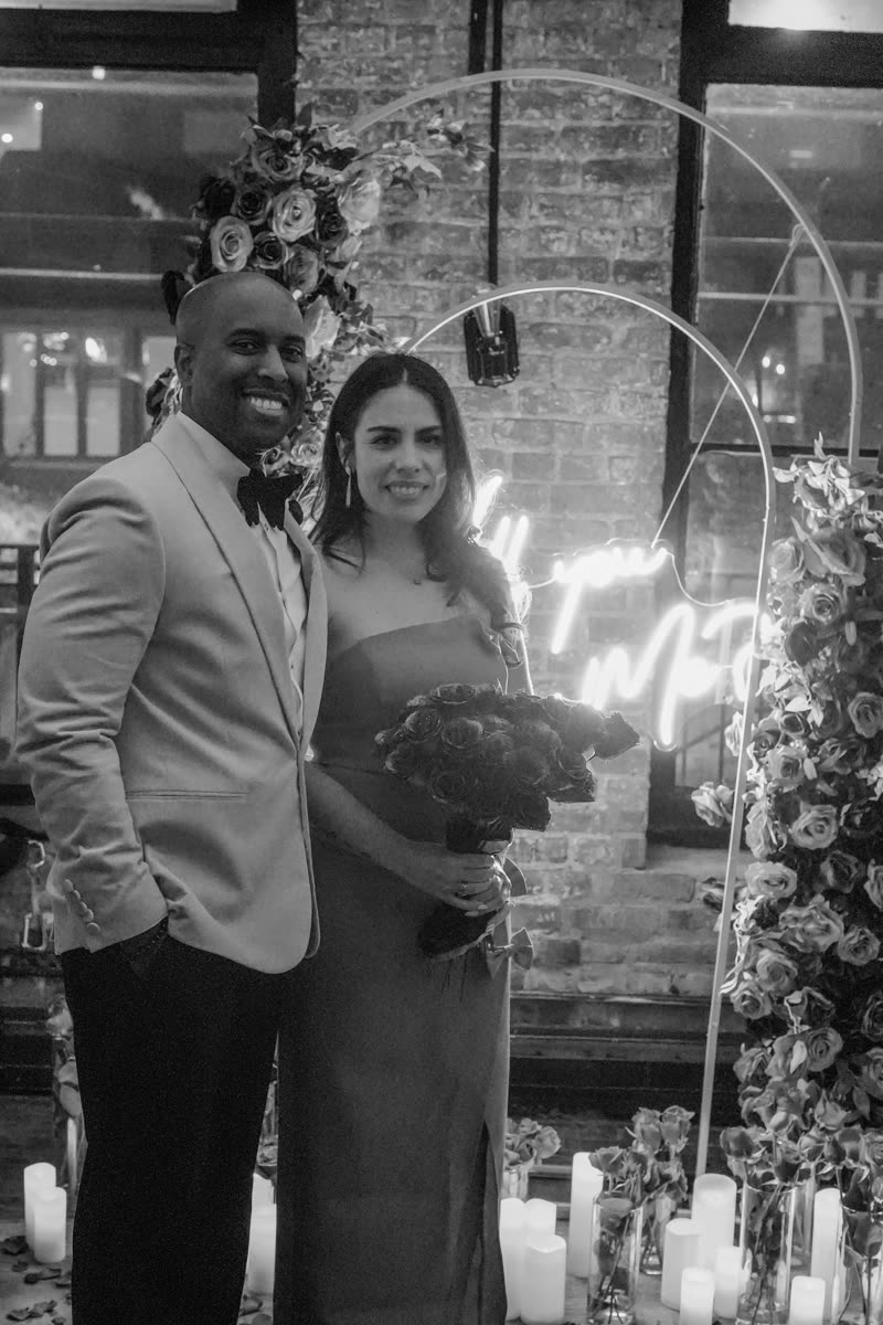 Alexandra and André smiling with a bouquet of roses